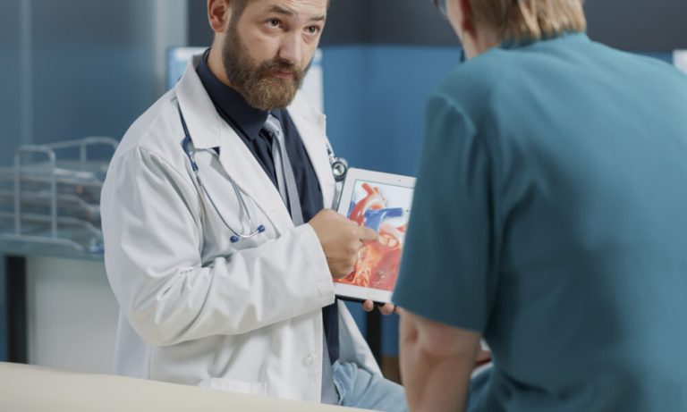 General practitioner holding tablet with heart condition